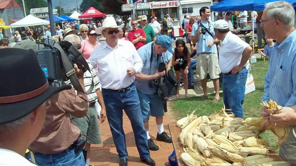 Macon County Manager Jack Horton acts as time keeper for the corn shucking contest