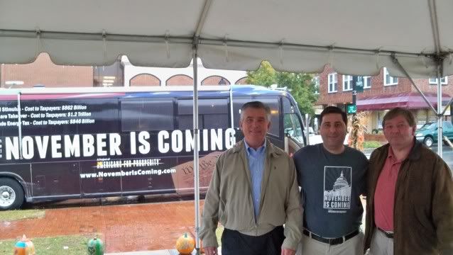 Jim Davis (L) dallas Woodhouse (C) and Gary Dills (R) pose in front of the November is Coming bus in Franklin, NC